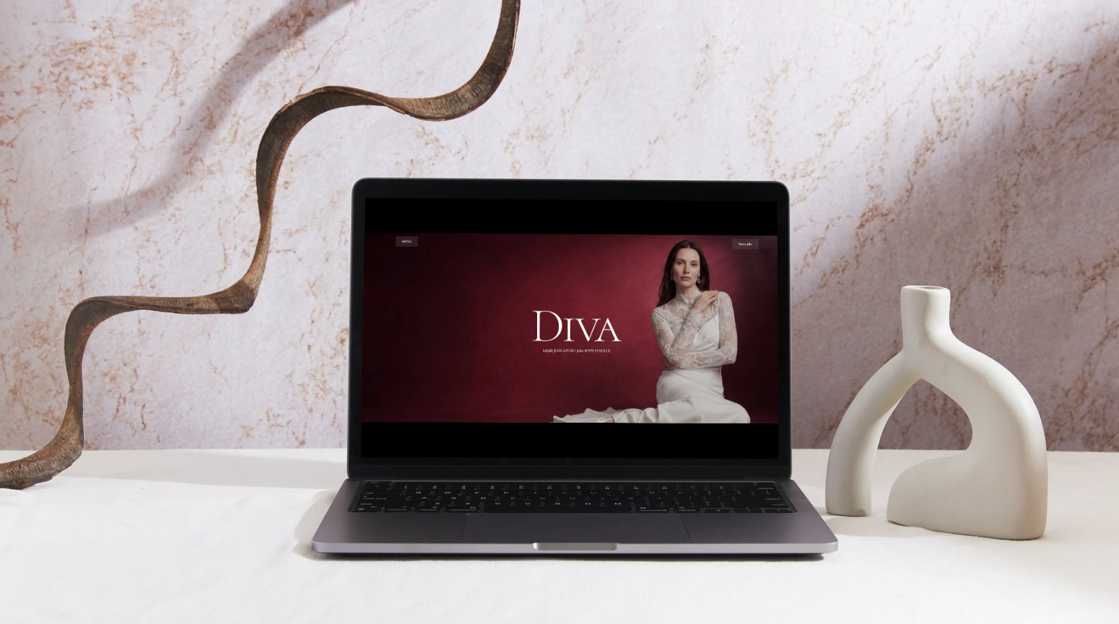Diva Boutique bridal website displayed on a laptop in a pale sculptural interior